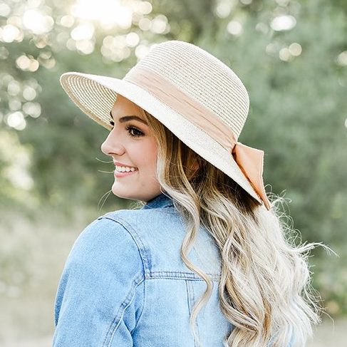 Eugene Oregon senior photos with girl posing outside with a denim jacket and cute sun hat 