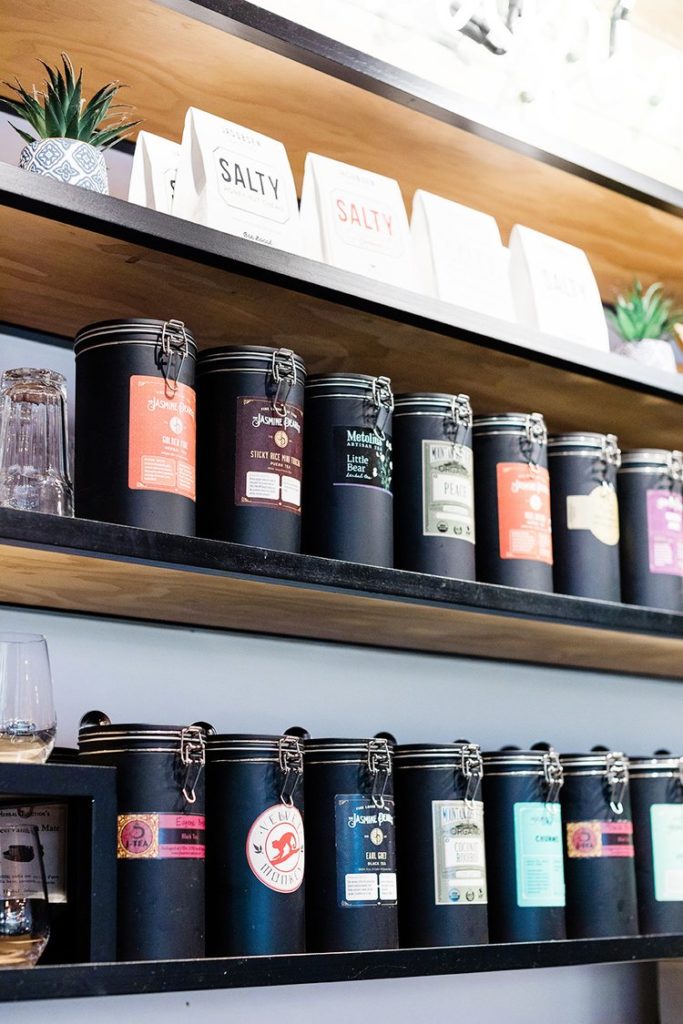 tea canisters on shelves with plants captured by Oregon branding photographer
