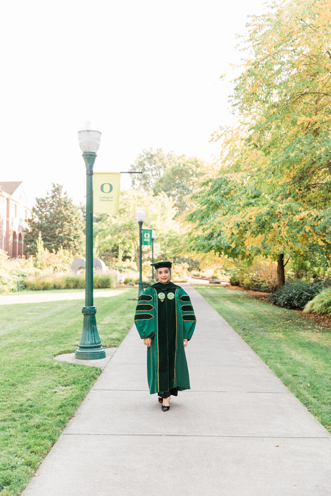 woman graduating green gown advanced degree