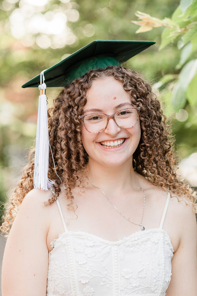 girl graduate graduation hat white dress trees buildings University of Oregon