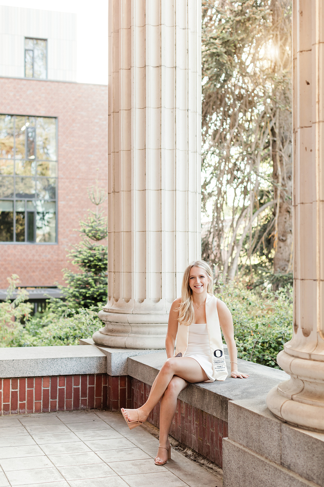 Girl wearing University of Oregon graduation stole on campus